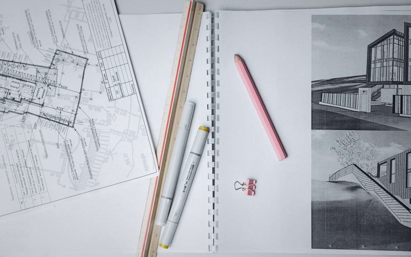 Technical drawing pens and a scale rule on a drafting sheet