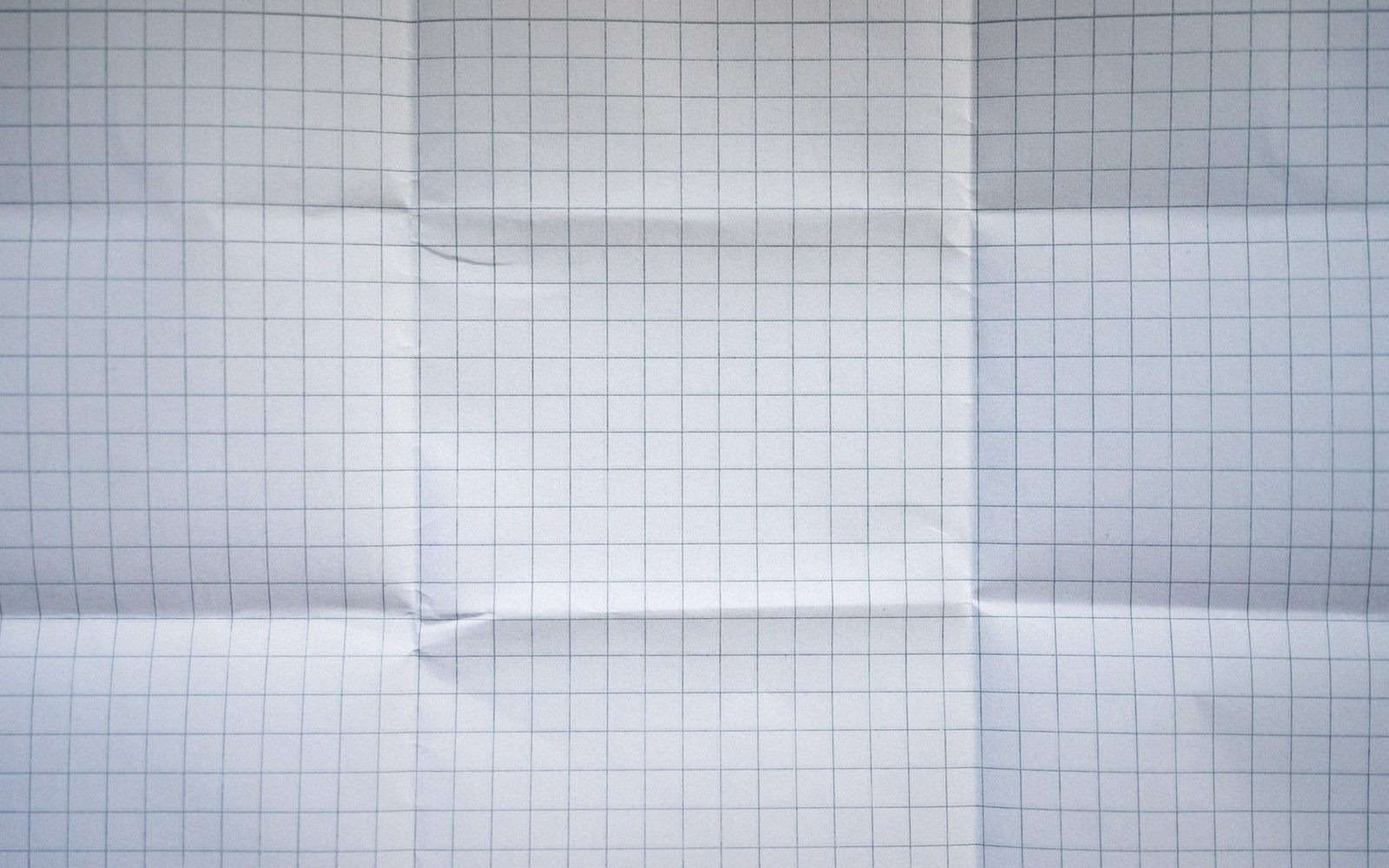 Blank grid paper with visible fold creases forming a symmetrical pattern