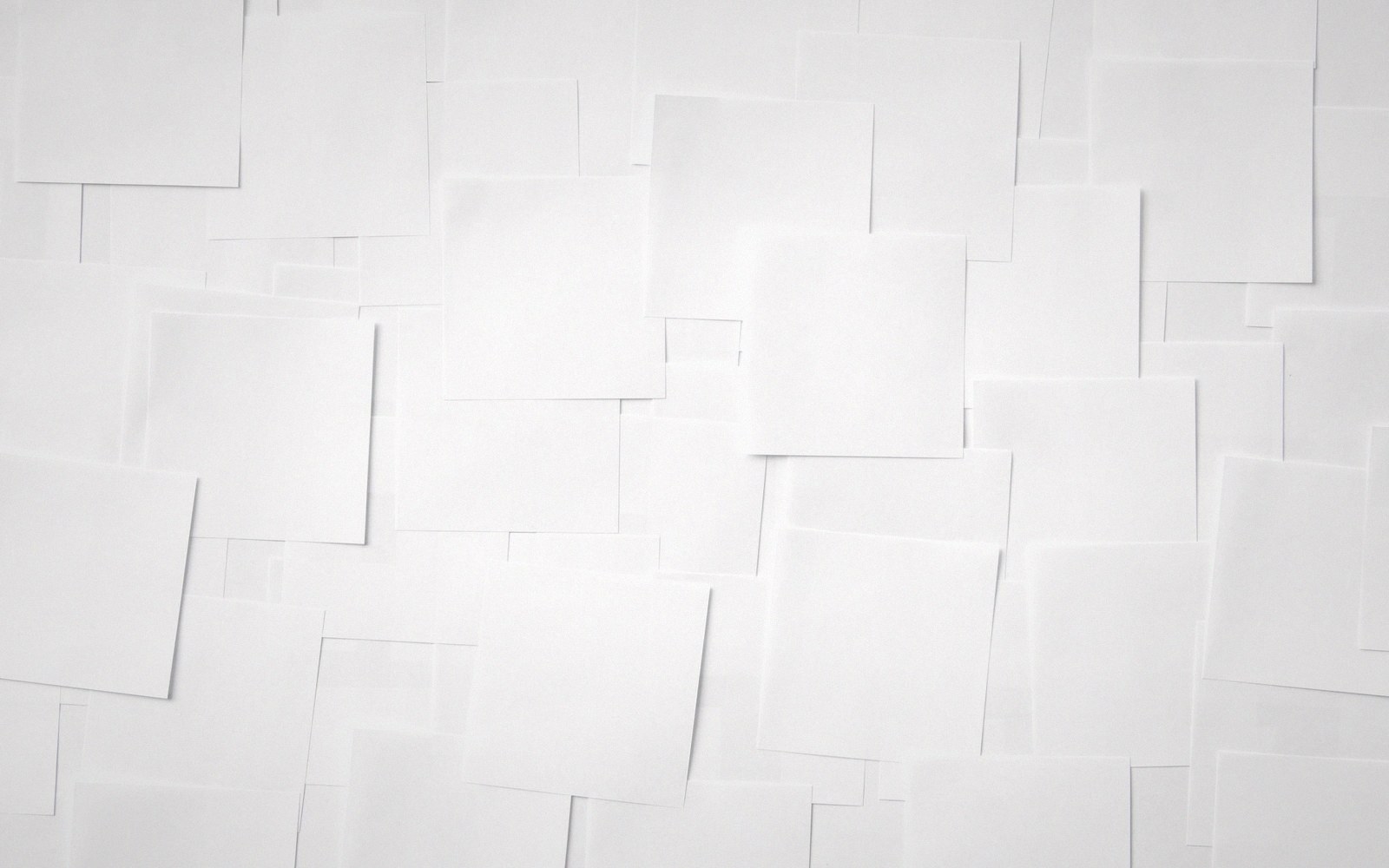 Overlapping blank white squares of paper arranged in a tiled, layered pattern